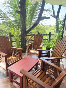 een groep stoelen en een houten tafel en bank bij The Nature Park Villa in Sigiriya
