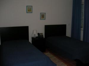 a bedroom with two beds and a lamp on a table at Reguengos Hotel in Reguengos de Monsaraz