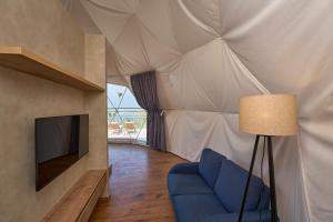 een woonkamer met een bank en een tv in een tent bij Astara Munnar in Munnar