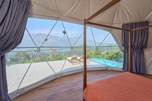 een kamer met een bed en uitzicht op een zwembad bij Astara Munnar in Munnar