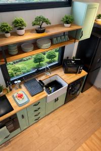 een keuken met een spoelbak en een raam bij Old Mill Tiny Homes in Kirk Leavington