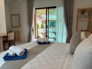 a bedroom with a bed with towels on it at Pinky Bungalows Resort & Villa in Ko Lanta