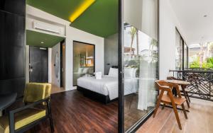 een slaapkamer met een bed en een bureau in een kamer bij Maha Resort Bali in Pererenan +25 foto's