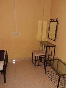 a room with a table and a mirror and a chair at Hotel Cosy Nook in Malvan