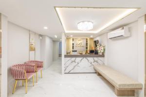 eine Lobby mit zwei Stühlen und einem Empfangstresen in der Unterkunft Believeinn in Bangkok