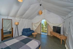a bedroom with a bed and a tv in a tent at Astara Munnar in Munnar +56 photos