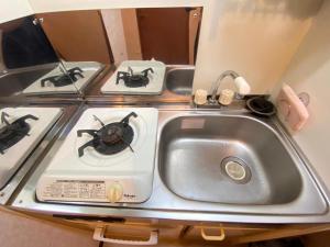 una cucina con fornelli e lavello di マルチステイ大阪京橋 ad Osaka Altre 8 foto