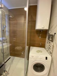 a washing machine in a bathroom with a shower at Pine Residence Zlatibor in Zlatibor +6 photos