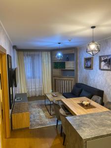a living room with a table and a couch at Pine Residence Zlatibor in Zlatibor