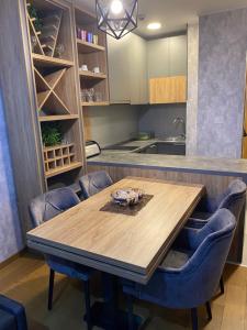 a kitchen with a wooden table and blue chairs at Pine Residence Zlatibor in Zlatibor