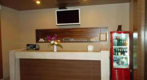 un bar con frigorifero rosso e una TV a parete di Honey Lodge a Pattaya Sud