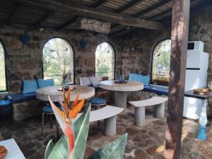 a room with two tables and chairs and windows at Quinta do Paraiso in São Teotónio