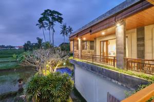 een balkon met uitzicht op een huis bij Long Lane Bali Villa in Ubud
