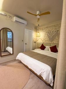 a bedroom with a large bed and a mirror at TWIN PALMS 'Beach House' - New surf front location in Thulusdhoo