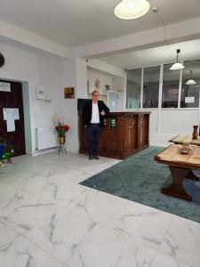 een man in een pak in een kamer bij Hotel NOU Codrin in Vatra Dornei