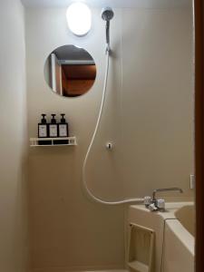 a bathroom with a shower and a sink and a mirror at Chalet GOROU in Hakuba +24 photos