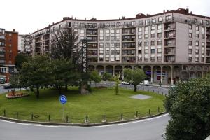 a large building with a park in front of it at Hotel San Jorge in Santurce