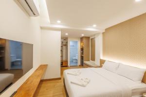 ein Schlafzimmer mit einem großen weißen Bett und ein Badezimmer in der Unterkunft Believeinn in Bangkok