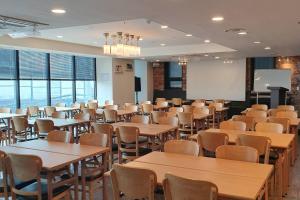 een grote kamer met tafels, stoelen en ramen bij CS Premier Hotel in Anyang