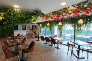 een restaurant met tafels en stoelen en bloemen aan het plafond bij CS Premier Hotel in Anyang