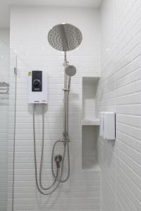 eine Dusche mit Duschkopf im Badezimmer in der Unterkunft Believeinn in Bangkok