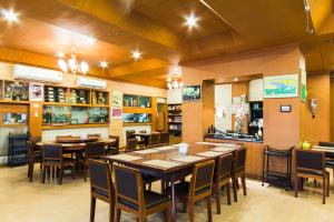 a restaurant with tables and chairs in a room at Roma Hotel in Khon Kaen