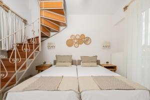 twee bedden in een kamer met een trap bij Spiros Family Apts in Laganas