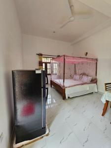 a room with a bed and a refrigerator in it at Pradeepa Villa in Weligama