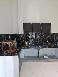 a kitchen with black and white marble counter top at Pradeepa Villa in Weligama