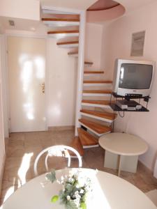 a living room with a staircase and a television at Villa Šoulavy in Kaštela