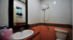 une salle de bains avec lavabo, toilettes et miroir dans l'établissement Phuttachot Resort, sur les Îles Phi Phi