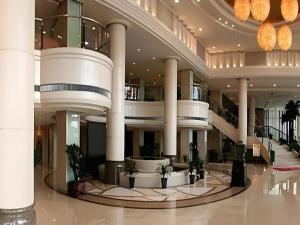 un grand bâtiment avec des colonnes et un hall avec des plantes dans l'établissement Datong Hotel, à Datong