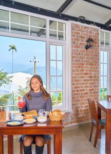 een vrouw die aan een tafel zit met een bord eten bij Astara Munnar in Munnar