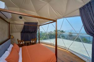 een tent met een bed, een tafel en een balkon bij Astara Munnar in Munnar +77 foto's
