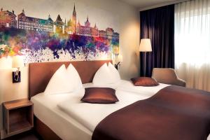 a hotel room with a large bed and a painting on the wall at Hotel Mercure Graz City in Graz