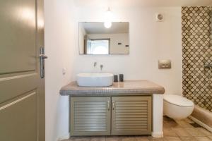 a bathroom with a sink and a toilet at Sunhaus in Perissa