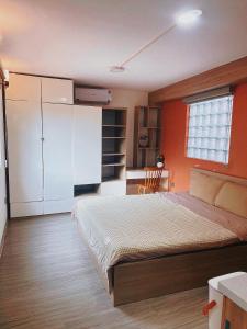 a bedroom with a large bed with an orange wall at Natural Light STU 402 Near Uncle Ho's Mausoleum in Hanoi