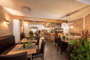 een restaurant met houten tafels en stoelen en een bar bij Genusshotel Almrausch in Bad Kleinkirchheim