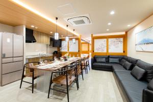 eine Küche und ein Wohnzimmer mit einem Tisch und einer Couch in der Unterkunft YOKOHAMA STAY PREMIER in Yokohama