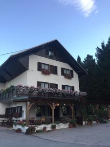 un gran edificio blanco con macetas de flores y balcones en Guest House Kmečki Hram, en Idrija