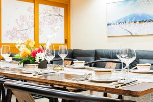 ein Tisch in einem Restaurant mit Weingläsern und Blumen in der Unterkunft YOKOHAMA STAY PREMIER in Yokohama