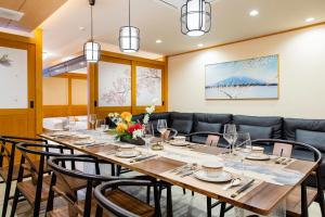 ein Esszimmer mit einem langen Tisch und Stühlen in der Unterkunft YOKOHAMA STAY PREMIER in Yokohama