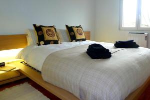 a bedroom with a bed with two bags on it at Vila Mar in Porto Covo