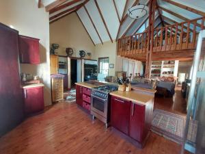 a large kitchen with a stove and a wooden floor at Tevreden in Rhodes