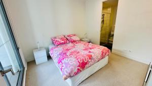a bedroom with a bed with pink sheets and pink pillows at Sydney Olympic Park 13Free Parking in Sydney