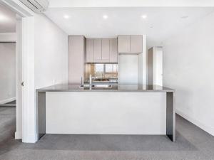 an empty kitchen with white cabinets and a sink at Sydney Olympic Park 13Free Parking in Sydney +6 photos