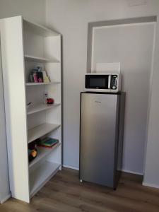 een magnetron bovenop een koelkast in een kamer bij Petit Brunò in Monfalcone