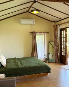 a bedroom with a green bed and a window at Sayu Homestay&Cafe in Ban Pha Mi