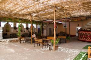 a room with tables and chairs and a man in the background at Jipek Joli Inn in Nukus