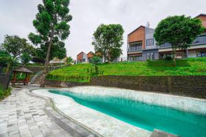 a swimming pool in front of a house at Naava Village in Tagalbato